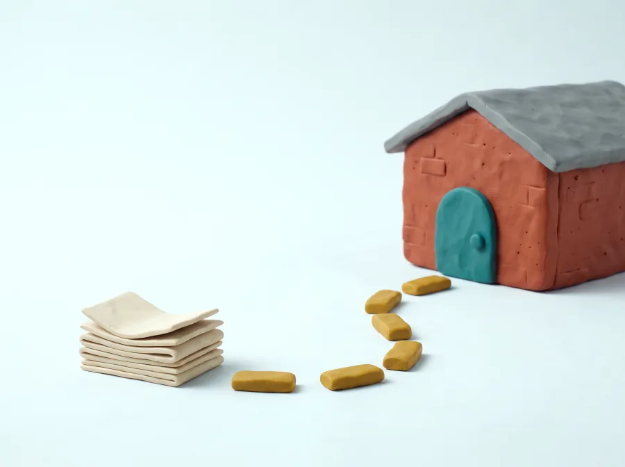 Klei-illustratie: een stapel bonnen met een gestippeld pad dat naar een loods aan de overkant van het terrein loopt.